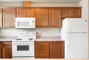 Spacious kitchen with a microwave, full-size fridge, and granite-like countertops. Natural light apartment Kennewick wa.at Pine Tree Park, Kennewick